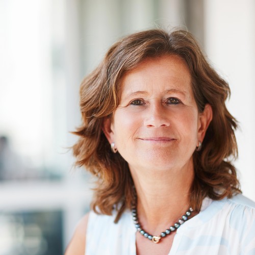 Eine lächelnde Frau in weißer Bluse