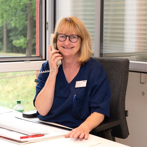 Eine lächelnde blonde Frau mit Brille telefoniert Eine lächelnde blonde Frau mit Brille telefoniert
