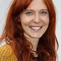 lächelnde Frau mit langen roten Haaren