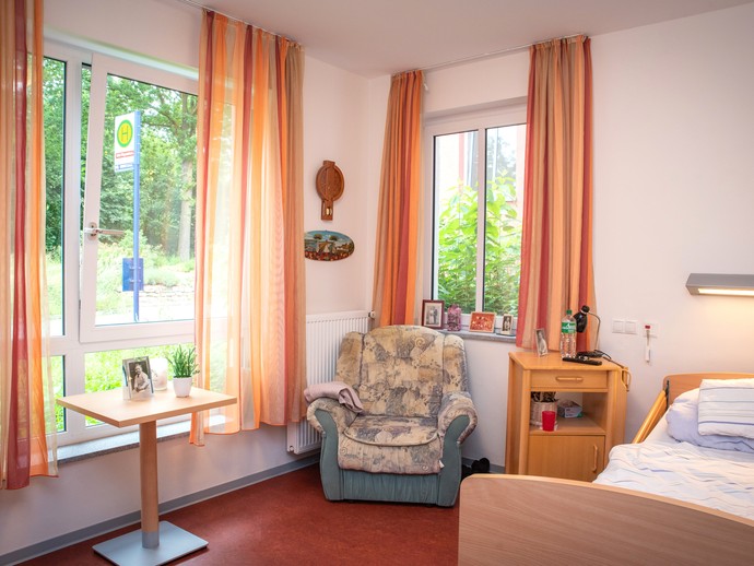 Zimmer mit gemütlichem Sessel und Blick ins Grüne
