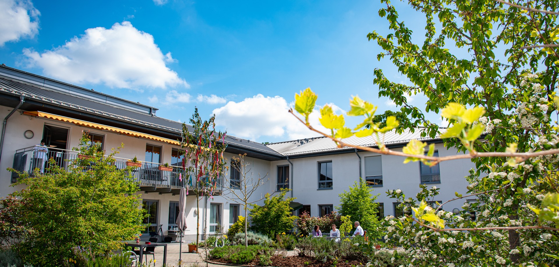 Personen sitzen im Garten des LWL-Pflegezentrums Personen sitzen im Garten des LWL-Pflegezentrums